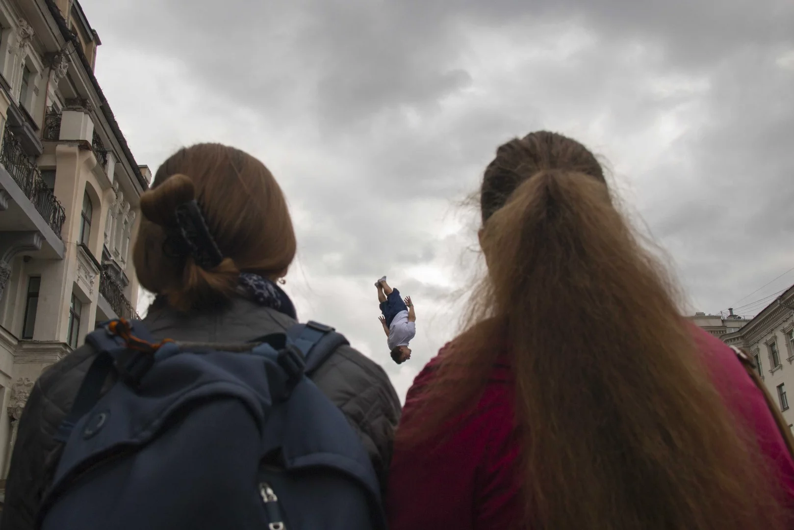 Finalist in The Photojournalist category of the 2018 EyeEm Awards. From the photographer: "This photo was taken in the city of Moscow on the holiday dedicated to the city. It was a great day to look for a photo frame. The guy fell from the sky and he had a choice between the girls, to whom to fall into the arms of love, but he was not determined and flew between them."