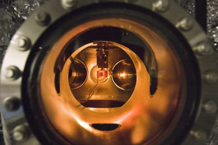 A small PETE device made with cesium-coated gallium nitride glows while being tested inside an ultra-high vacuum chamber (Image: Nick Melosh)