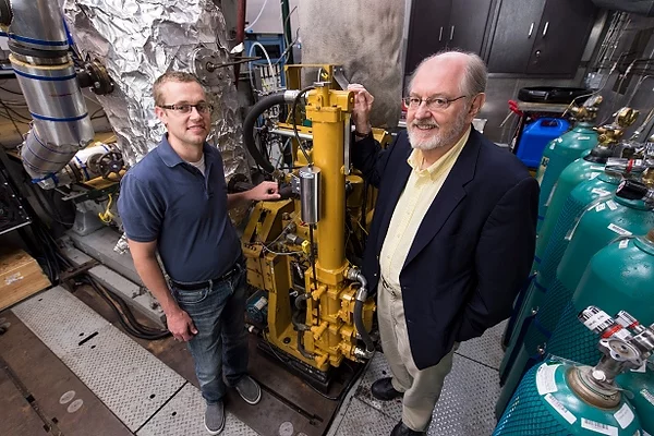 Assistant professor Sage Kokjohn (left) and Rolf Reitz with the original Cat engine