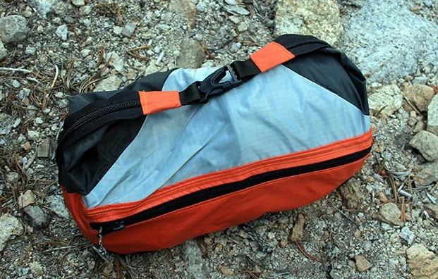 The Grub Hub Cirque folds up into a small carry case that holds a backpacking stove, pot fuel and cooking tools