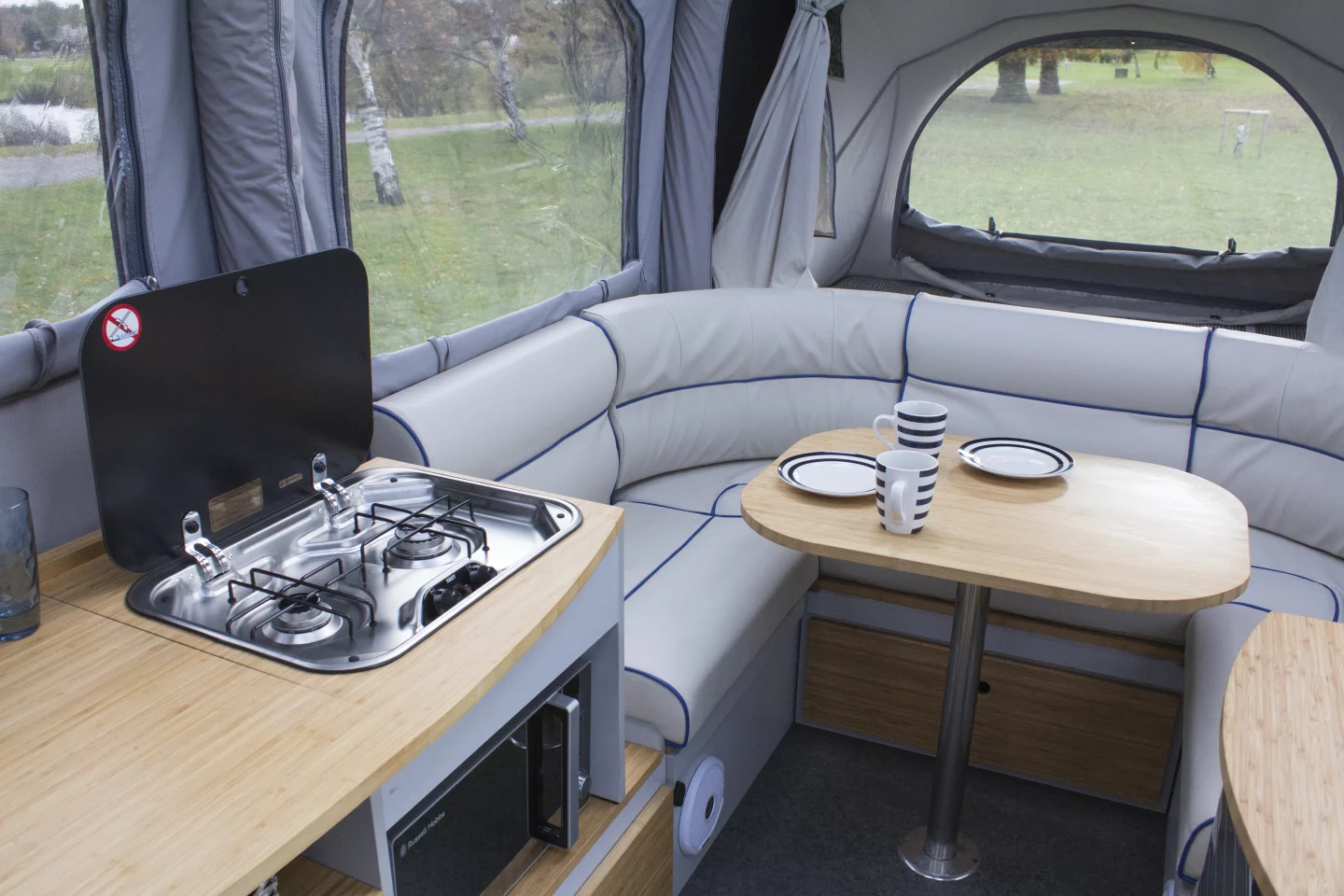 The Opus Camper interior includes a U-shaped sofa, kitchen unit and two end beds
