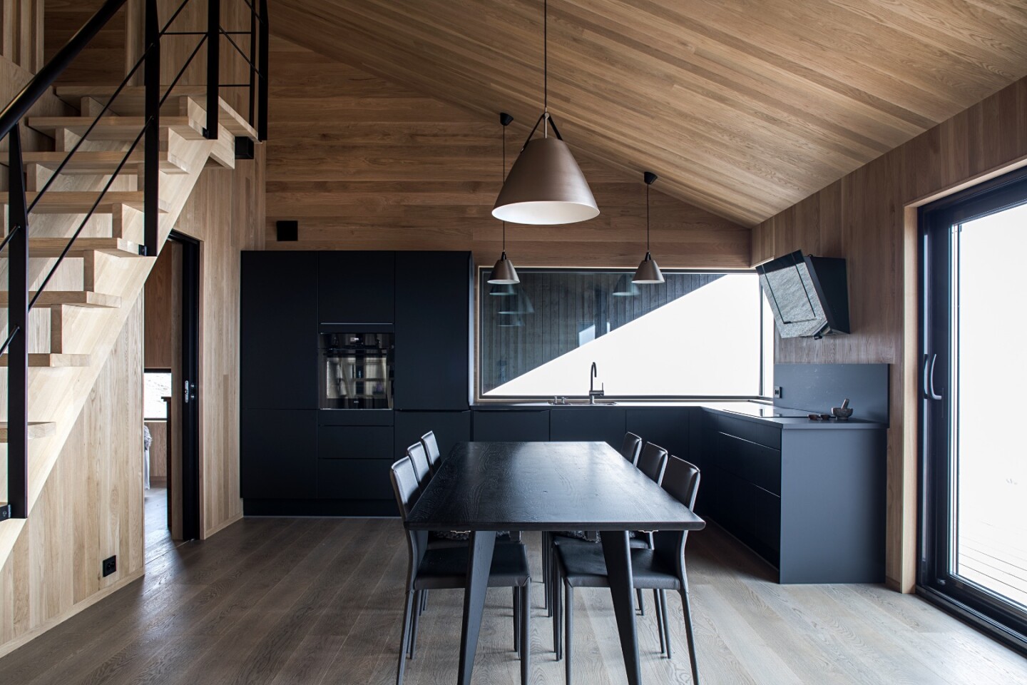 Inside, the cabin is arranged around an open living area with a living room, kitchen, and dining area