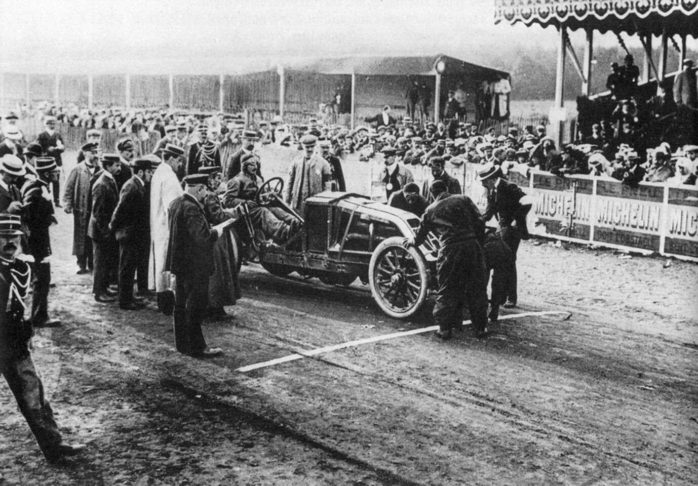 Ferenc Szisz in the factory Renault Grand Prix car on the grid at the 1906 Grand Prix - the first Grand Prix in history. Szisz won the race and the Grand Prix (Great Prize) to the winner of 45,000 French francs. The franc was pegged to the gold price at 0.290 grams per franc, which meant that the prize was worth 13 kg of gold (US$661,500 in today's money).