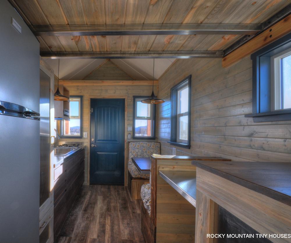 The Ol’ Berthoud Blue's kitchen includes a seating booth and table for two that folds out into a 6 ft (1.8 m)-long bed
