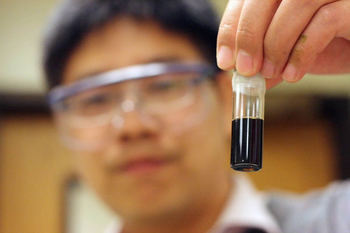 Peigao Duan, a University of Michigan graduate student, holds a vial of bio-oil
