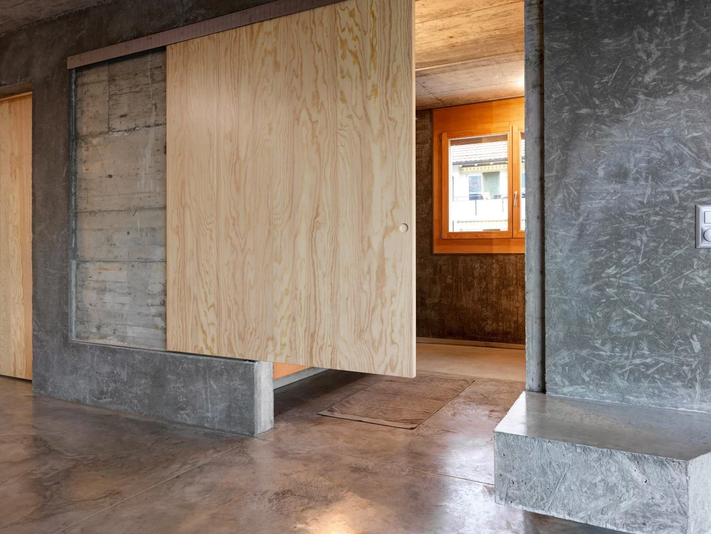 A sliding wooden door provides access to the bathroom
