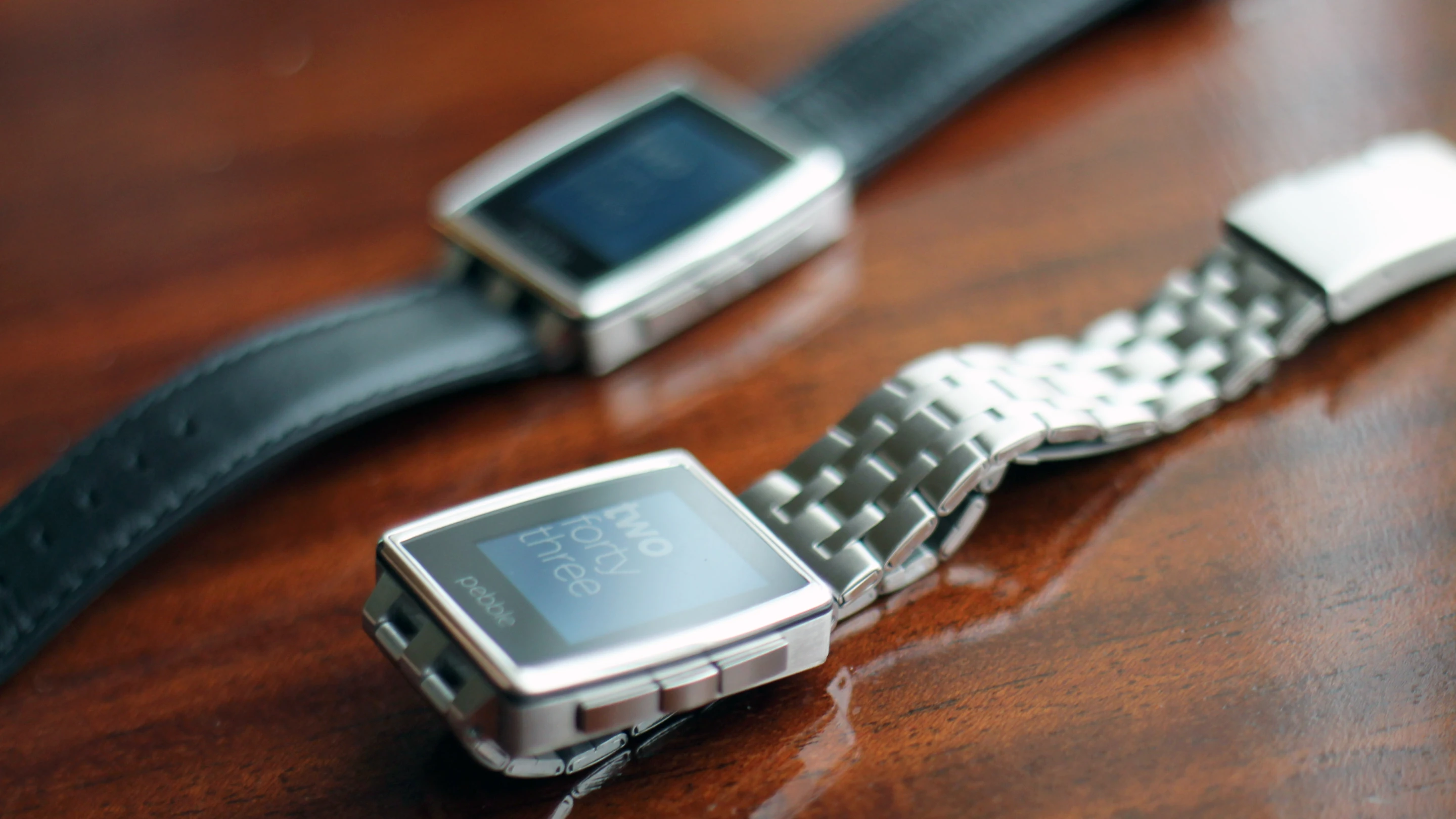 The Brushed Stainless Steel will ship with a Brushed Stainless band (foreground) as well as a black leather one (background)