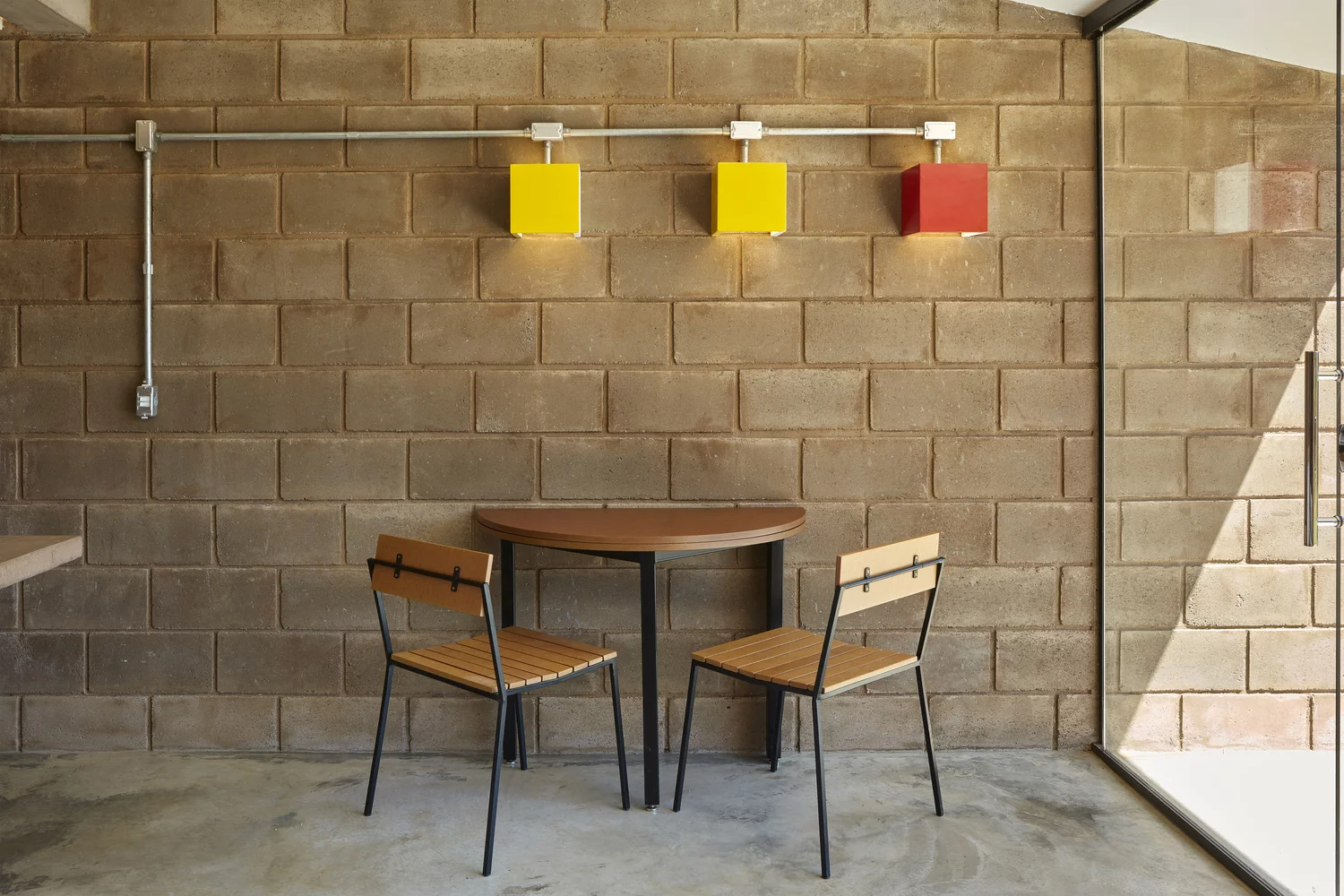 Sustentable House features a minimal meals area with exposed cabling