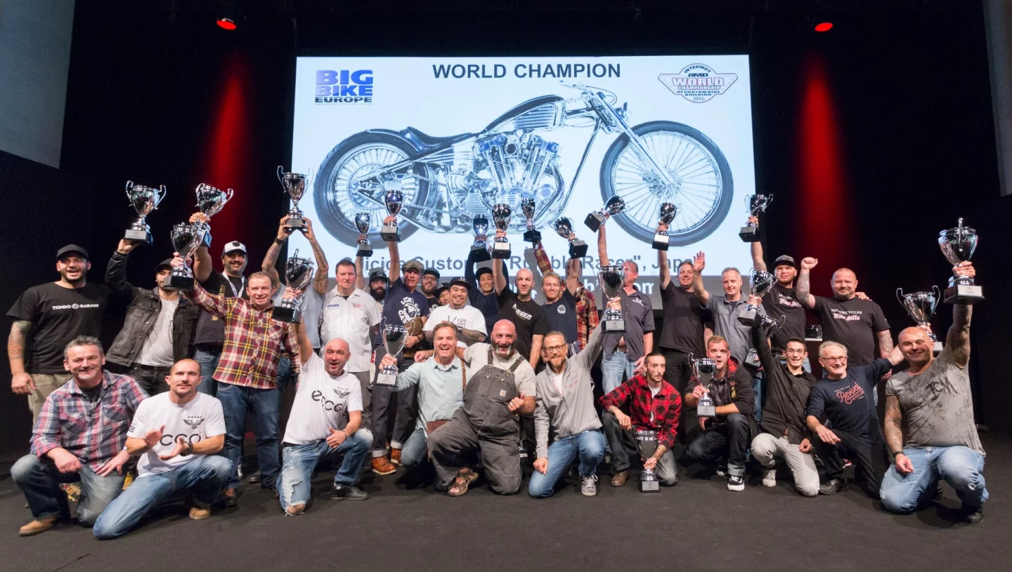 All the competitors of the AMD World Championship of Custom Bike Building pose for a group photo with the winning Rumble Racer from Suicide Customs (Japan) in the background