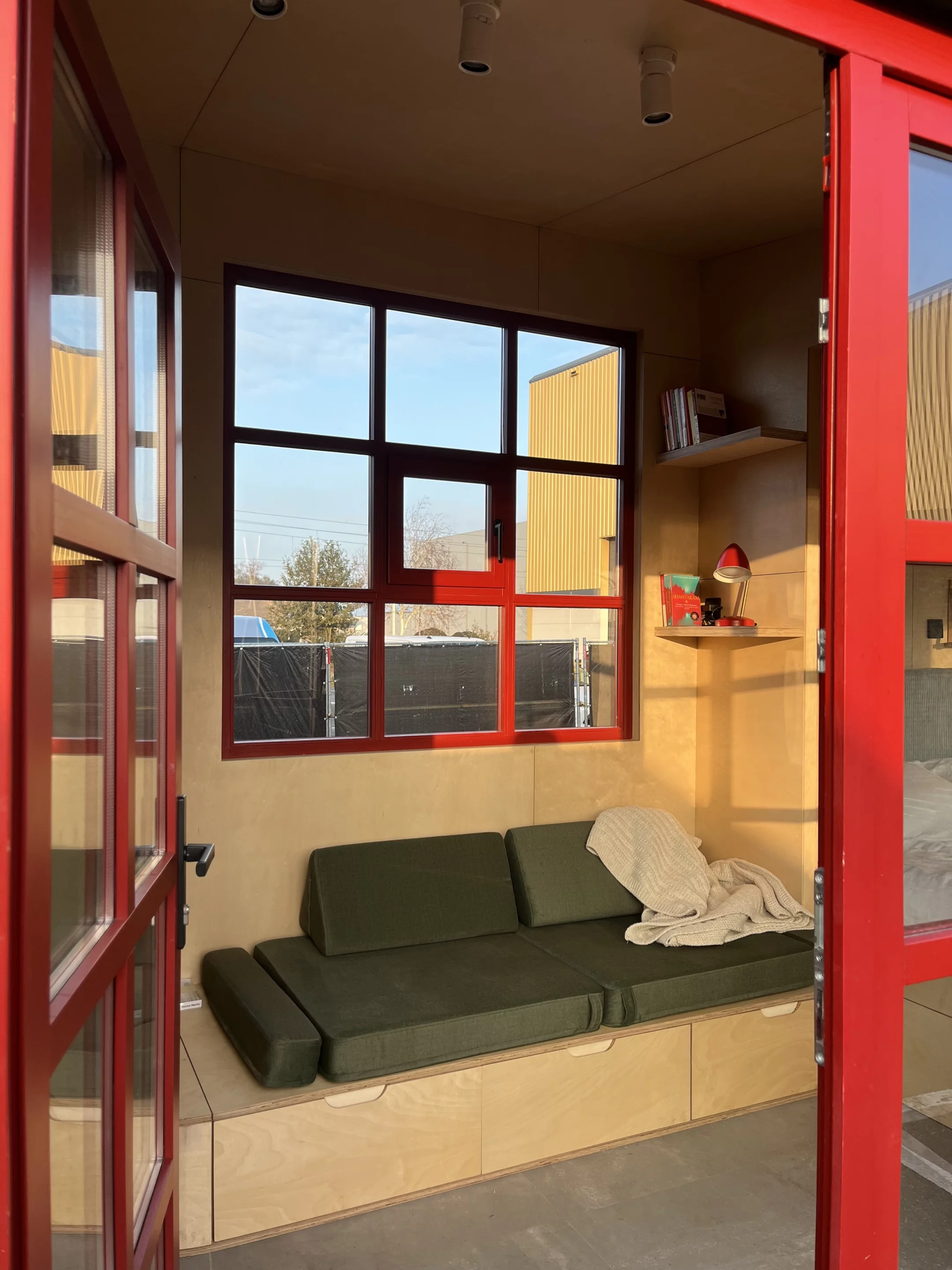 The THOW's entrance opens onto its living room, which includes a sofa and storage space