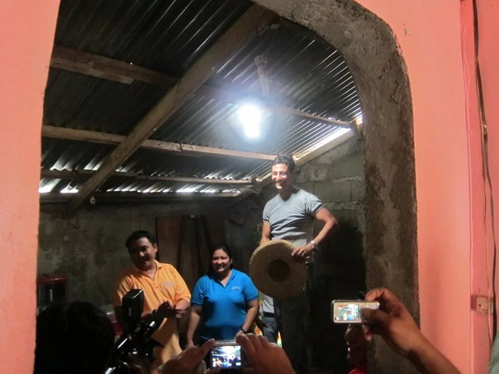 Illac Diaz (right) in a home equipped with one of his Solar Bottle Bulbs(Photo: Isang Litrong Liwanag)