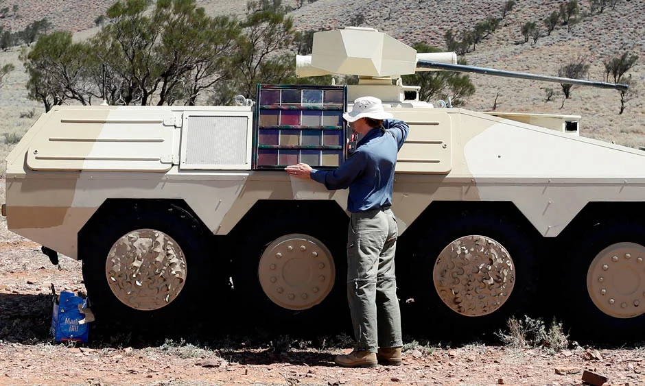 A researcher shows the various tank colors that could be achieved with an electrical current