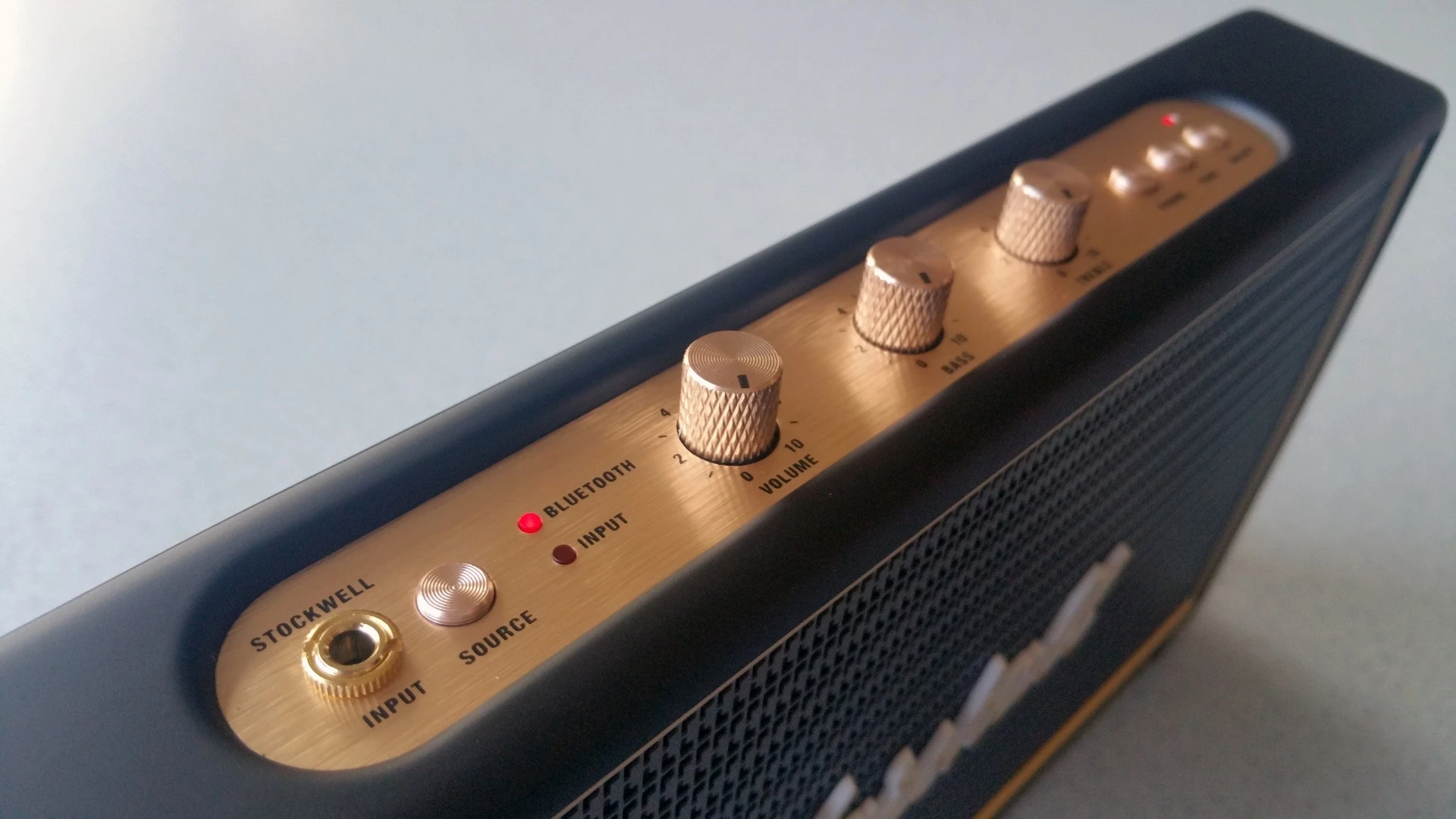 The analog knobs to adjust volume, bass, and treble are retractable within the brushed metal surface