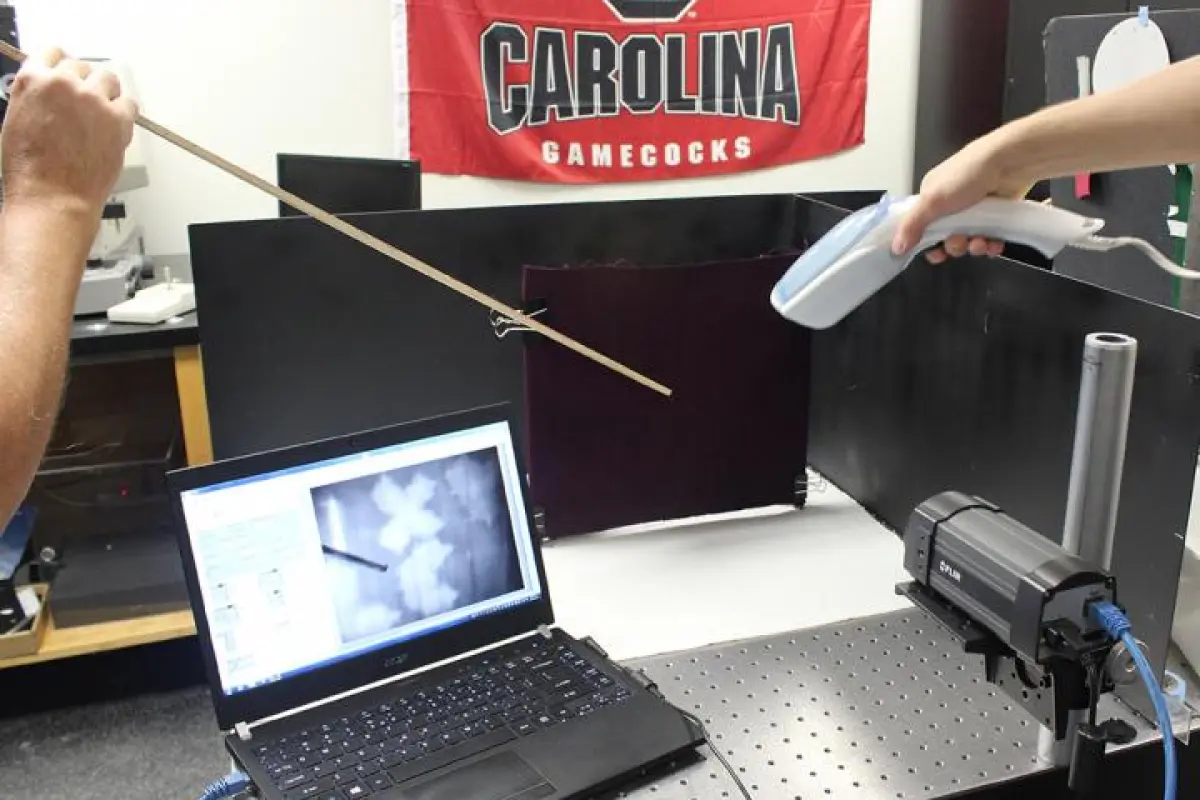 A hand steamer and an infrared camera are used to reveal blood markings on a black background