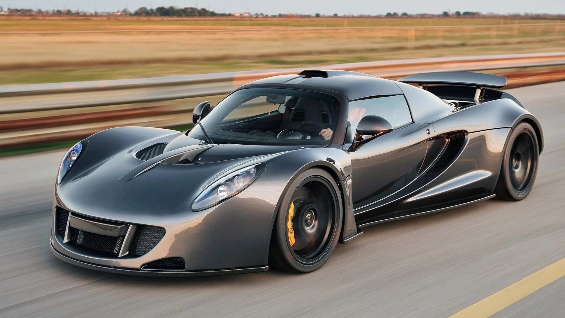 In April, 2013 the Hennessey Venom GT hit the headlines with a 265.7 mph (428 km/h) timed speed, bringing with it quite a controversy. The Hennessey Venom GT is manufactured by Texas-based Hennessey Performance Engineering, based on a heavily modified Lotus Exige chassis with massive American V8 muscle packed in.