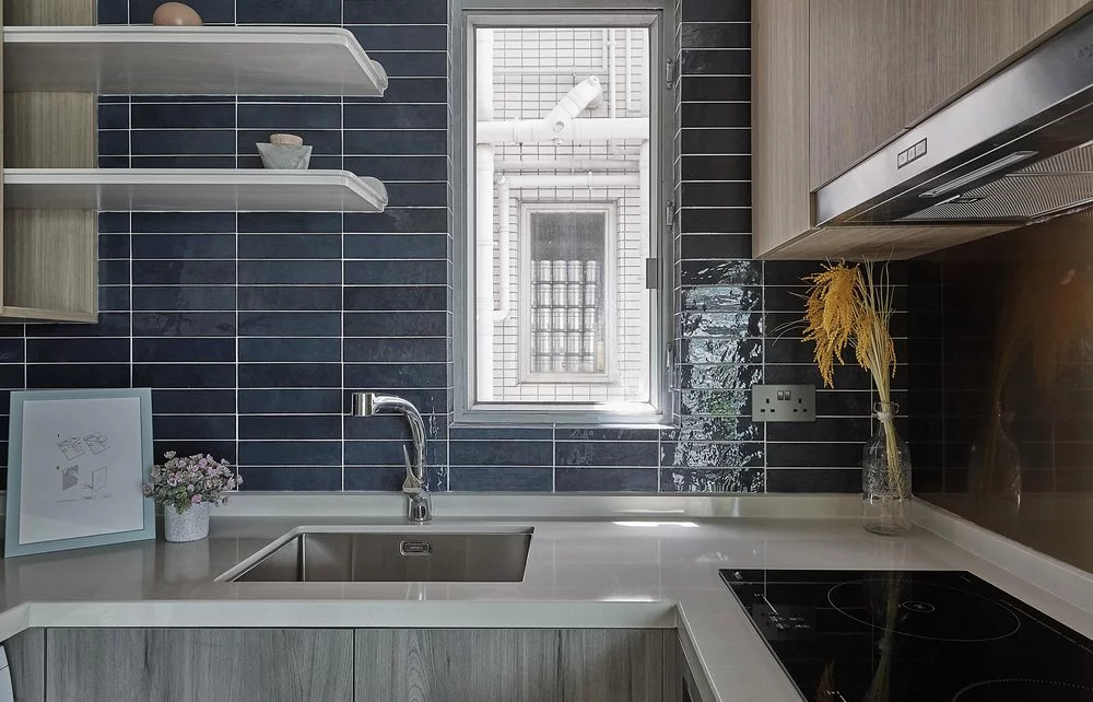 The contemporary kitchen is complete with blue tiling, gold-plated stainless steel splash-back wall, and an induction cook-top to reduce cooking fumes