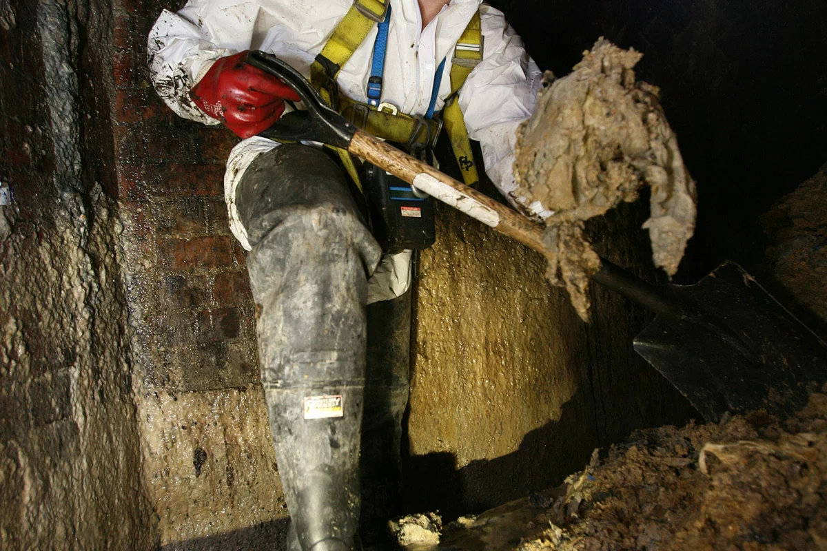 A Thames Water employee clearing fat from beneath London's Leicester Square