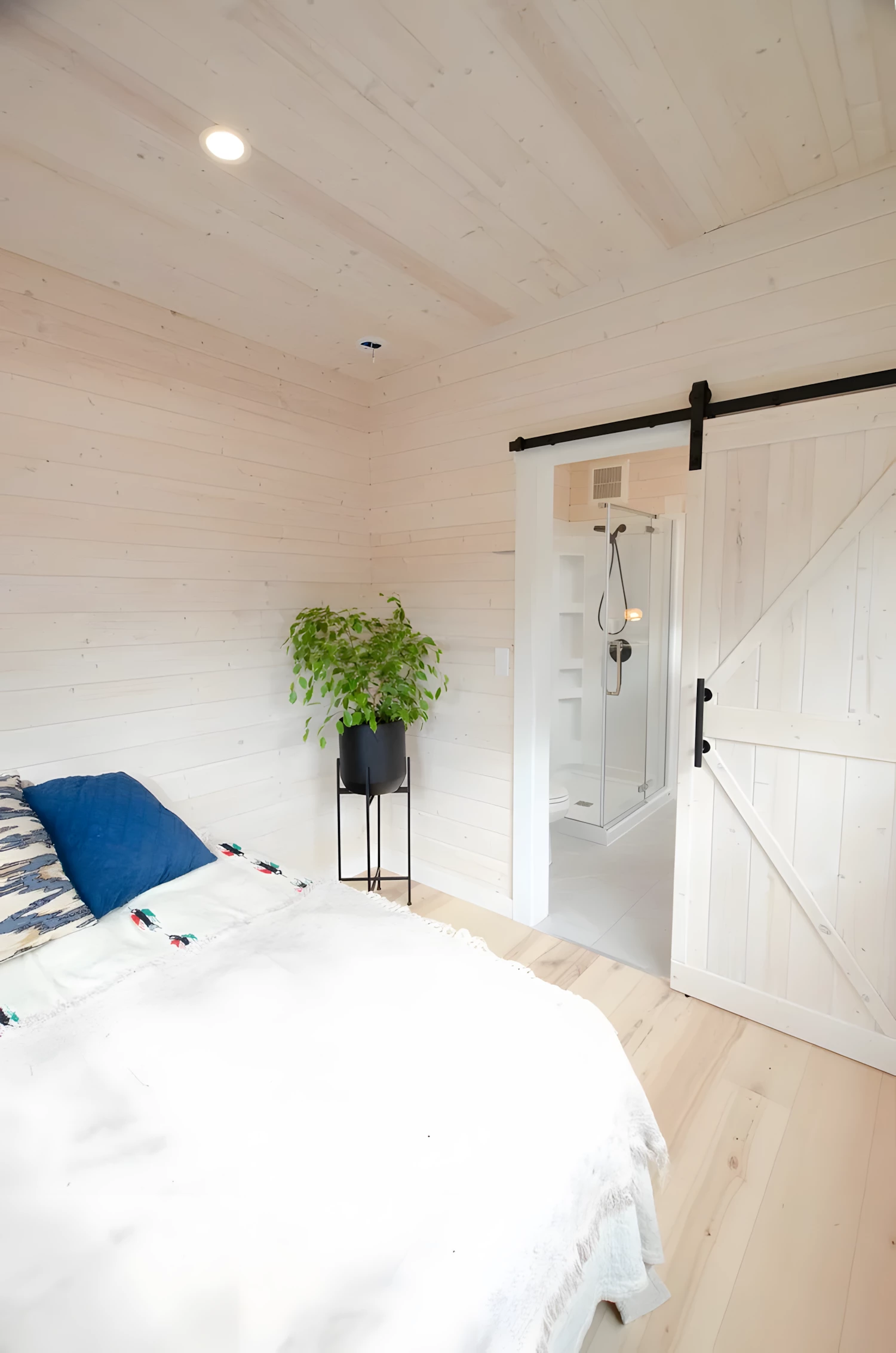 The Barred Owl features sliding barn‑style doors for both the bathroom and bedroom