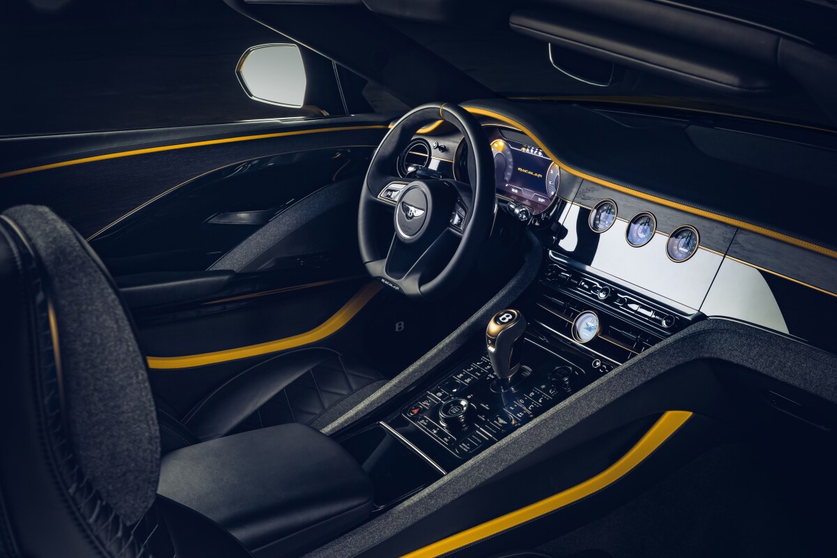 The touchscreen hides behind the dash, replaced by a river wood panel with gauges