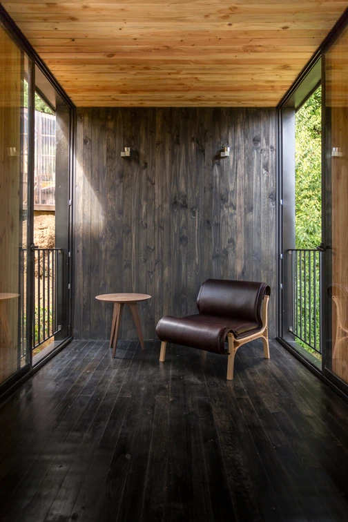Inside the home features beautiful dark timber flooring and a mixture of black and untreated natural timber cladding on the walls and ceilings