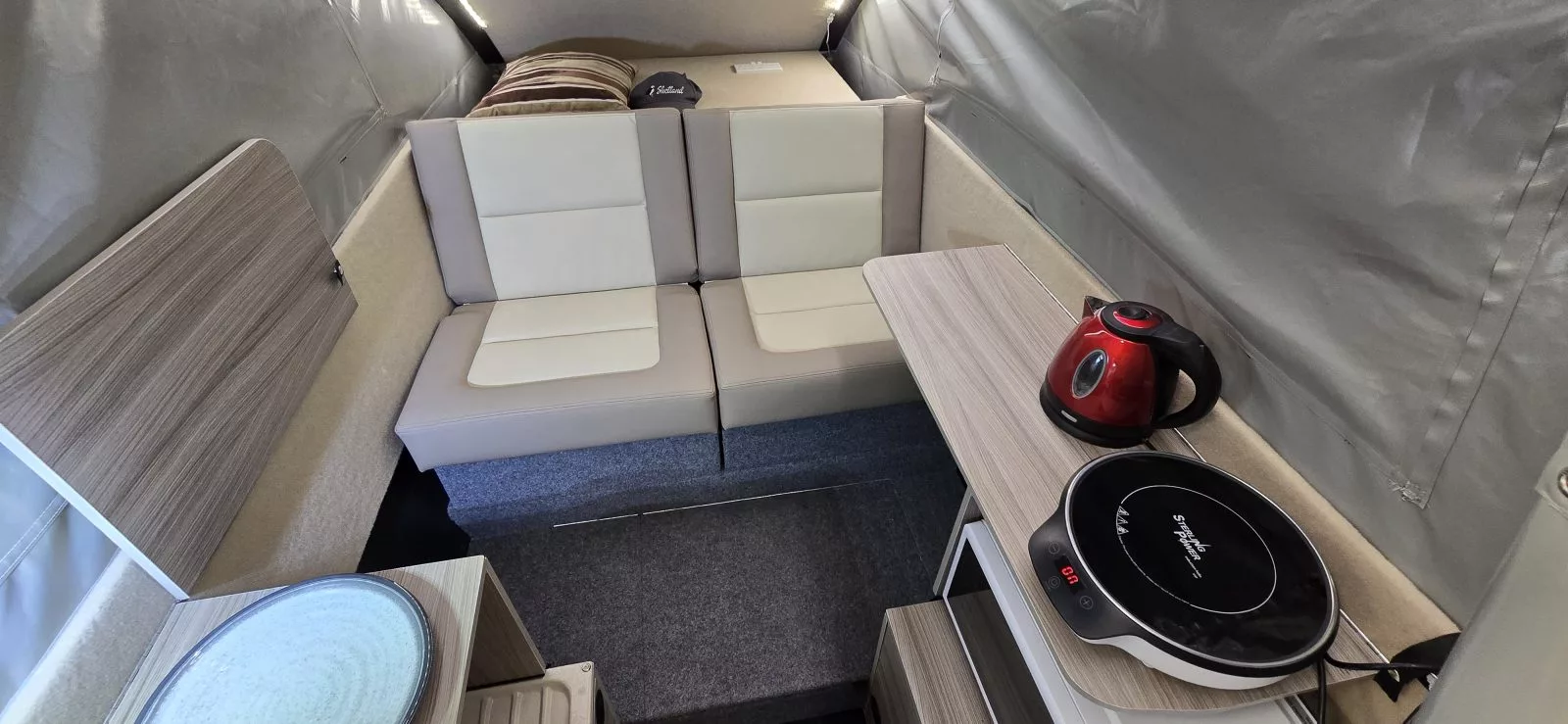 Since the ECT 2 has an extra seat where the ECTS (Solo) has its kitchen counter, the two-seater relies on its fold-down shelf and a portable induction cooker