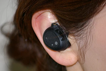The compact wearable device slots into people's ears like a regular earbud