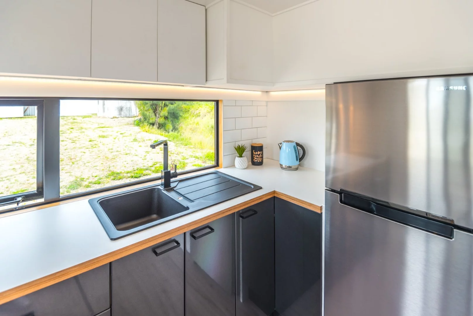 The Pohutukawa design includes a full kitchen complete with fridge/freezer, overhead and under bench cupboards and drawers