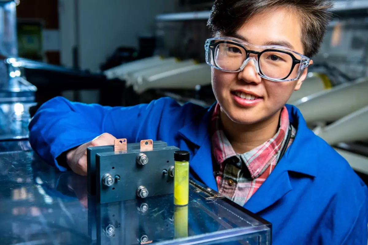 Flow battery researcher Ruozhu Feng poses with ingredients for a long-lasting grid energy battery