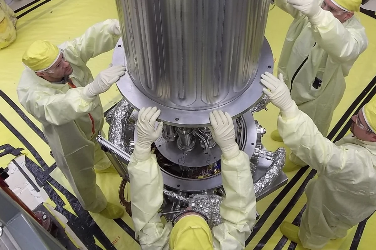 NASA and NNSA engineers lower the wall of the vacuum chamber around the Kilowatt Reactor Using Stirling TechnologY (KRUSTY system)