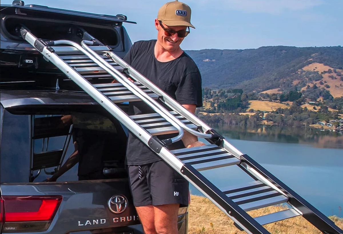Pulling the height-adjustable folded ladder out of its storage compartment