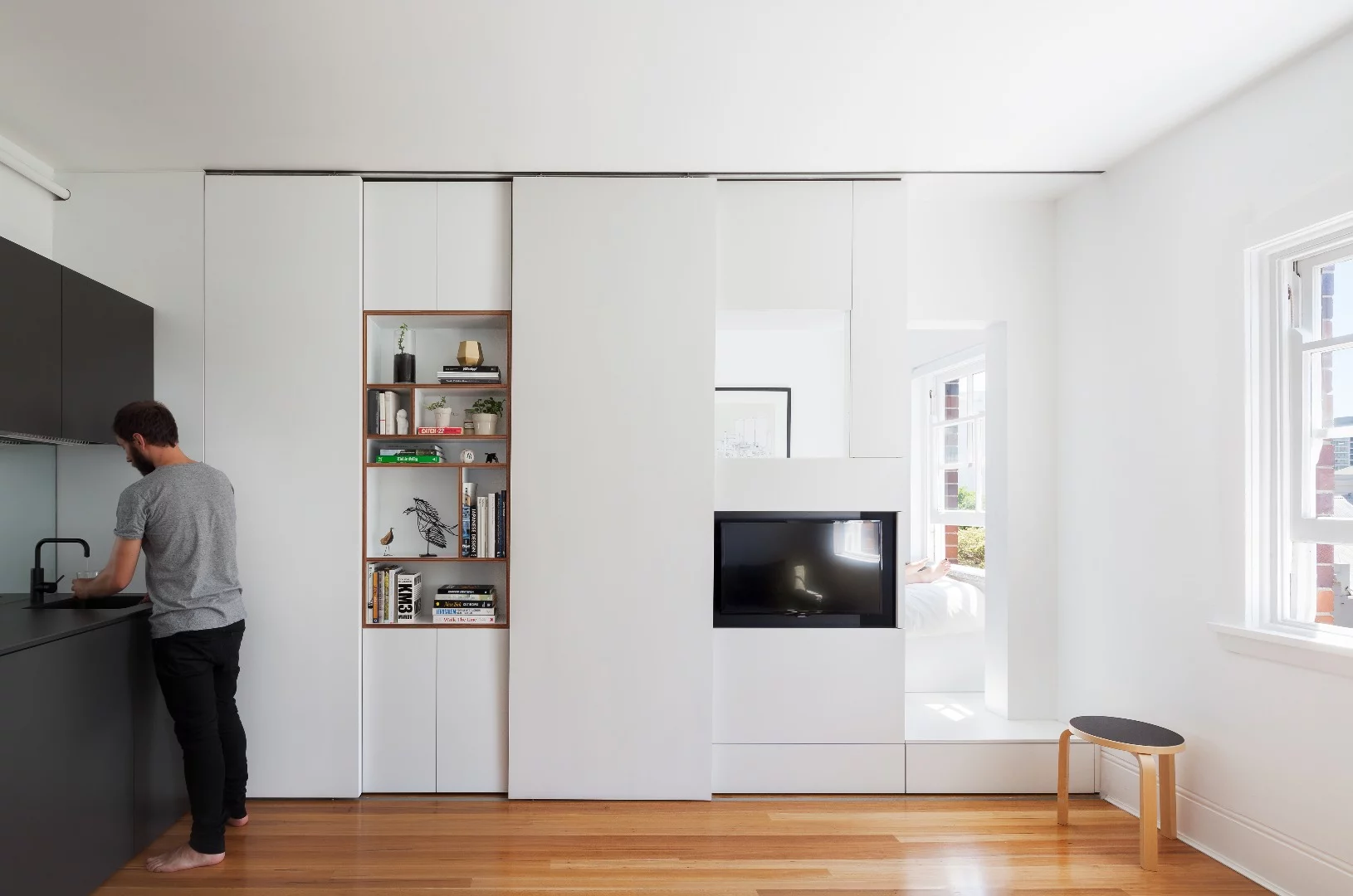The tiny apartment features ample storage space, multi-purpose zones, clean lines and lots of natural light