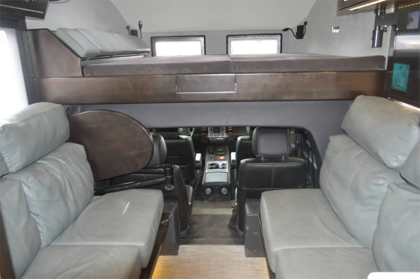 Electric-folding side couches and an upper bed provide sleeping space