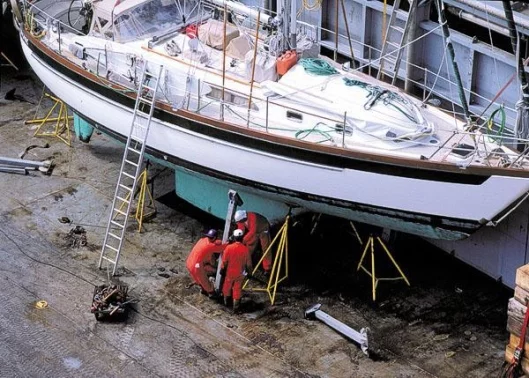 Dockwise technicians securing a yacht for transport.