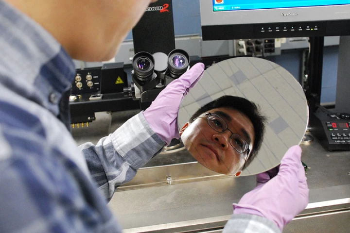 IBM researcher Hongsik Park examines a wafer packed with carbon nanotubes