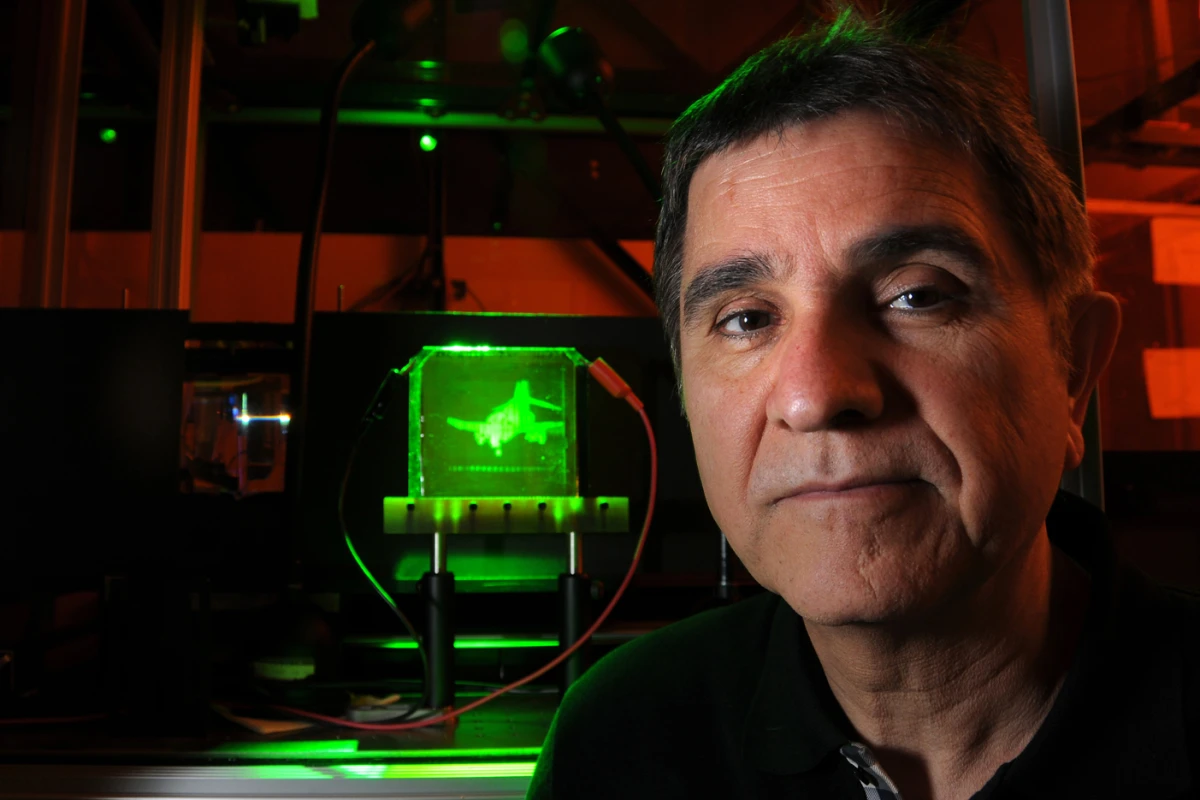 Project leader Nasser Peyghambarian with a refreshable, holographic image of an F-4 Phantom jet (Photo: University of Arizona)
