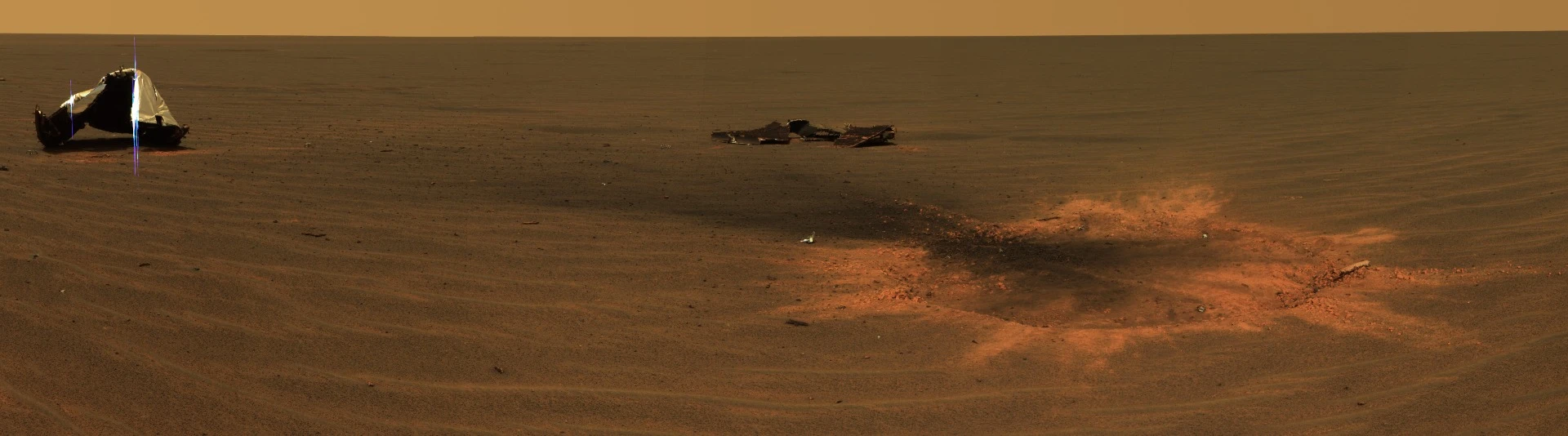 Opportunity landing site showing the discarded heat shield and a bounce crater caused by the impact of the lander