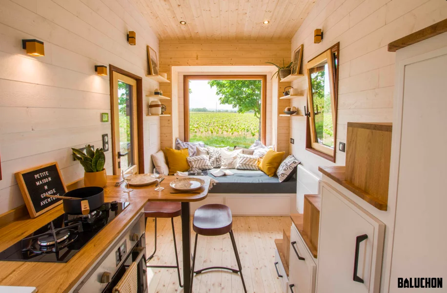 The Piccola Casa's kitchen includes a propane-powered stove, an oven, a sink, and some cabinetry