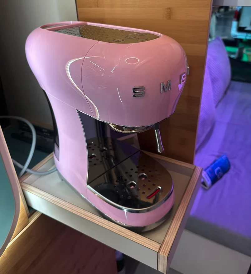A color-matched Smeg coffeemaker slides out from a cabinet for morning coffee