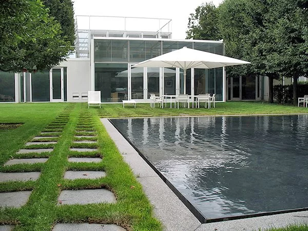 Rear view of Taghkanic House, showing the outdoor pool, patio, glassed-in social space, underground rooms, and the framework of the glass pavilion (Photo: T. Phifer and Partners)