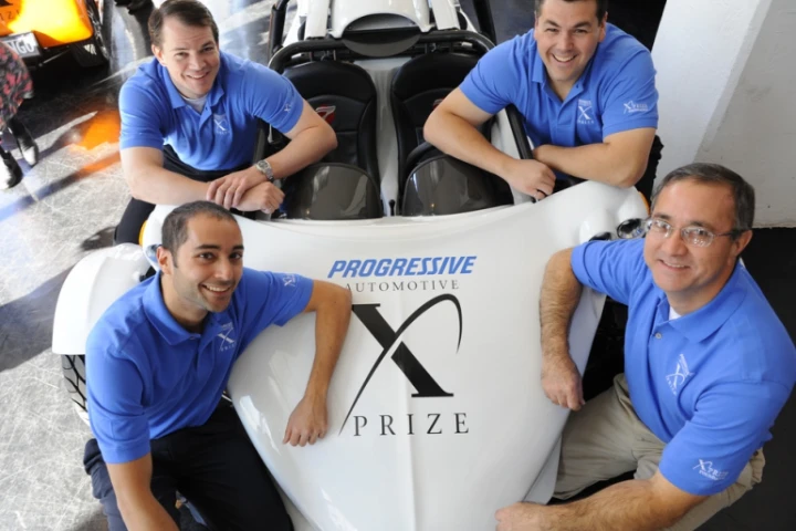 Team OptaMotive members (clockwise from top right: Mark Demers, Mike Nispel, Murat Ozkan and Michael Worry) with their E-Rex electric vehicle which has qualified for the next round in the Progressive Insurance Automotive X Prize competition