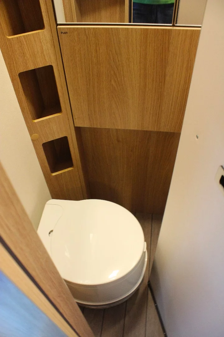 The compact Knaus Travelino toilet room includes a fold-down sink over the toilet