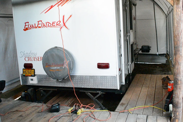 The trailer is parked inside the cabin/carport