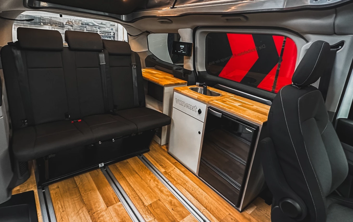 Vanexxt stocks this show Tourneo Custom camper van with a three-seat bench-bed plus refrigerator, sink and shelf modules
