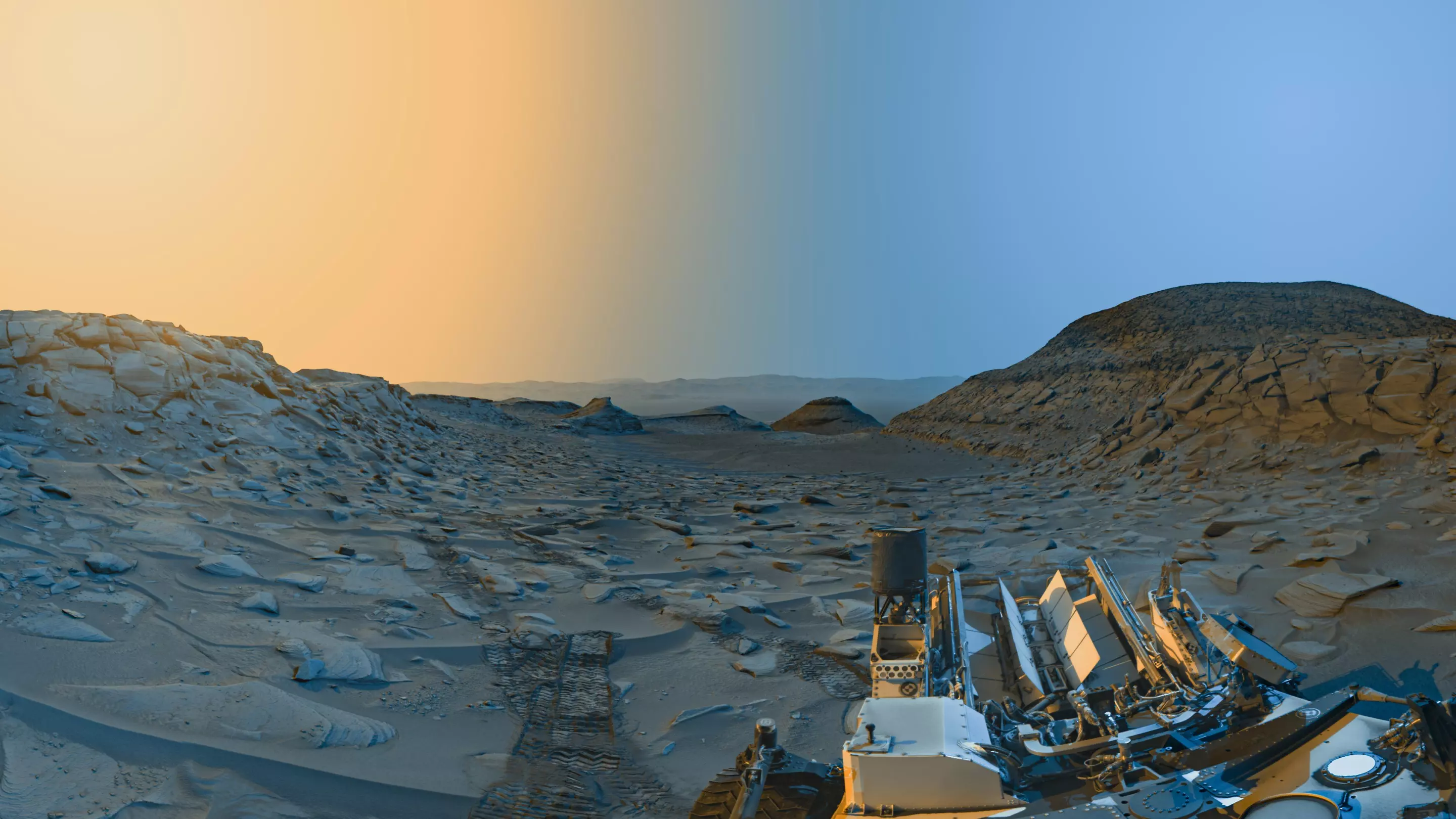 A panoramic "postcard" from the Curiosity rover on Mars, snapped in two bursts during one day back in April 2023. The blue side was captured in the Martian morning, and the yellow side that afternoon
