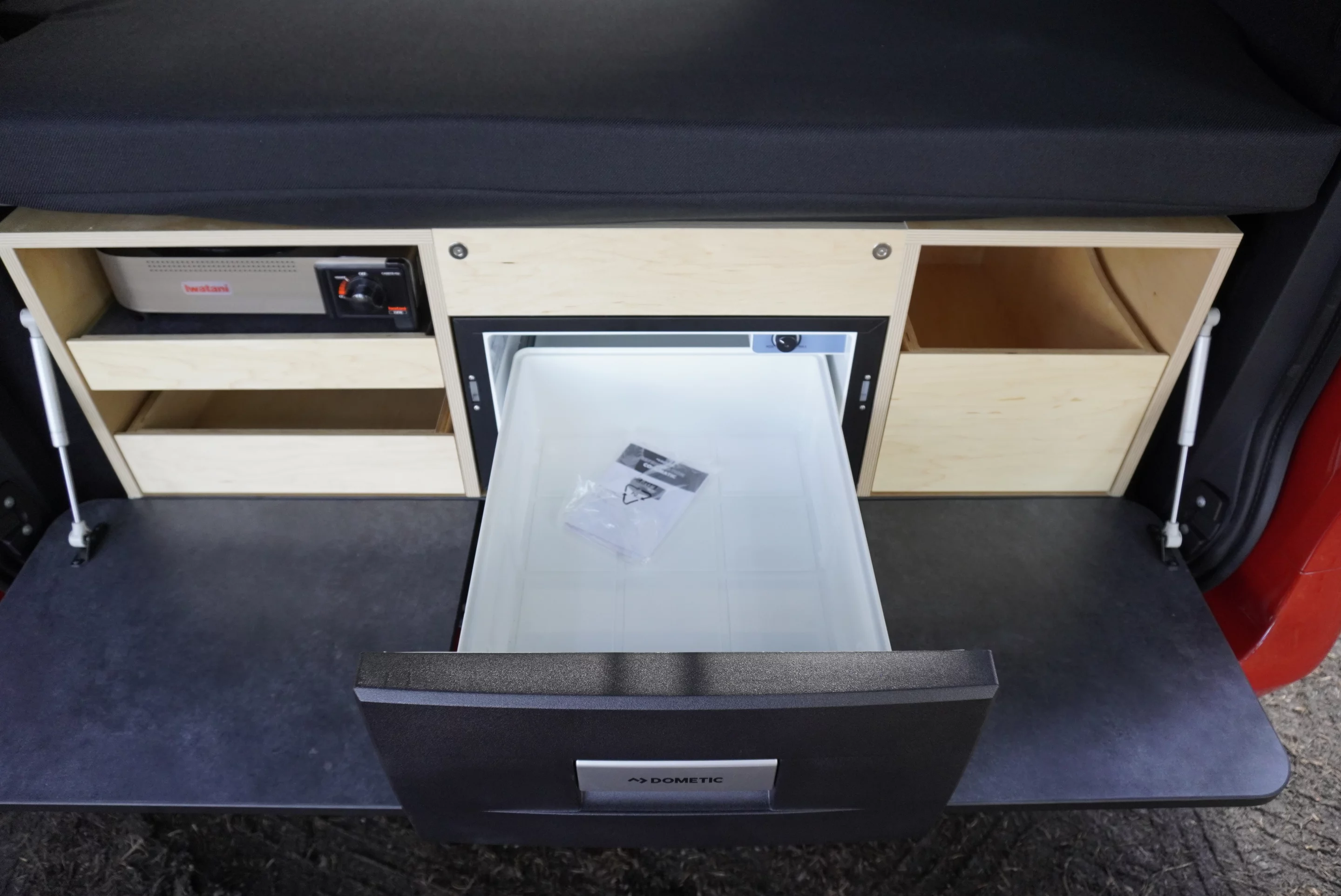 The kitchen includes a central fridge drawer
