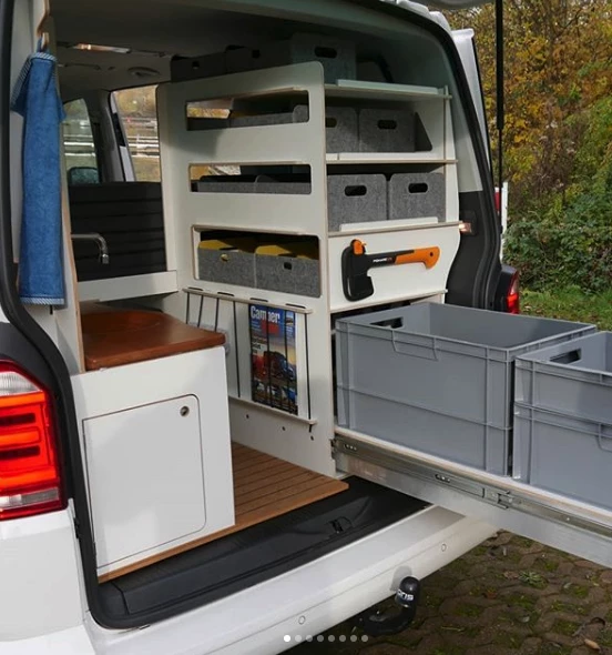 The optional toilet room includes a large storage console with slide-out and a bench toilet/sink