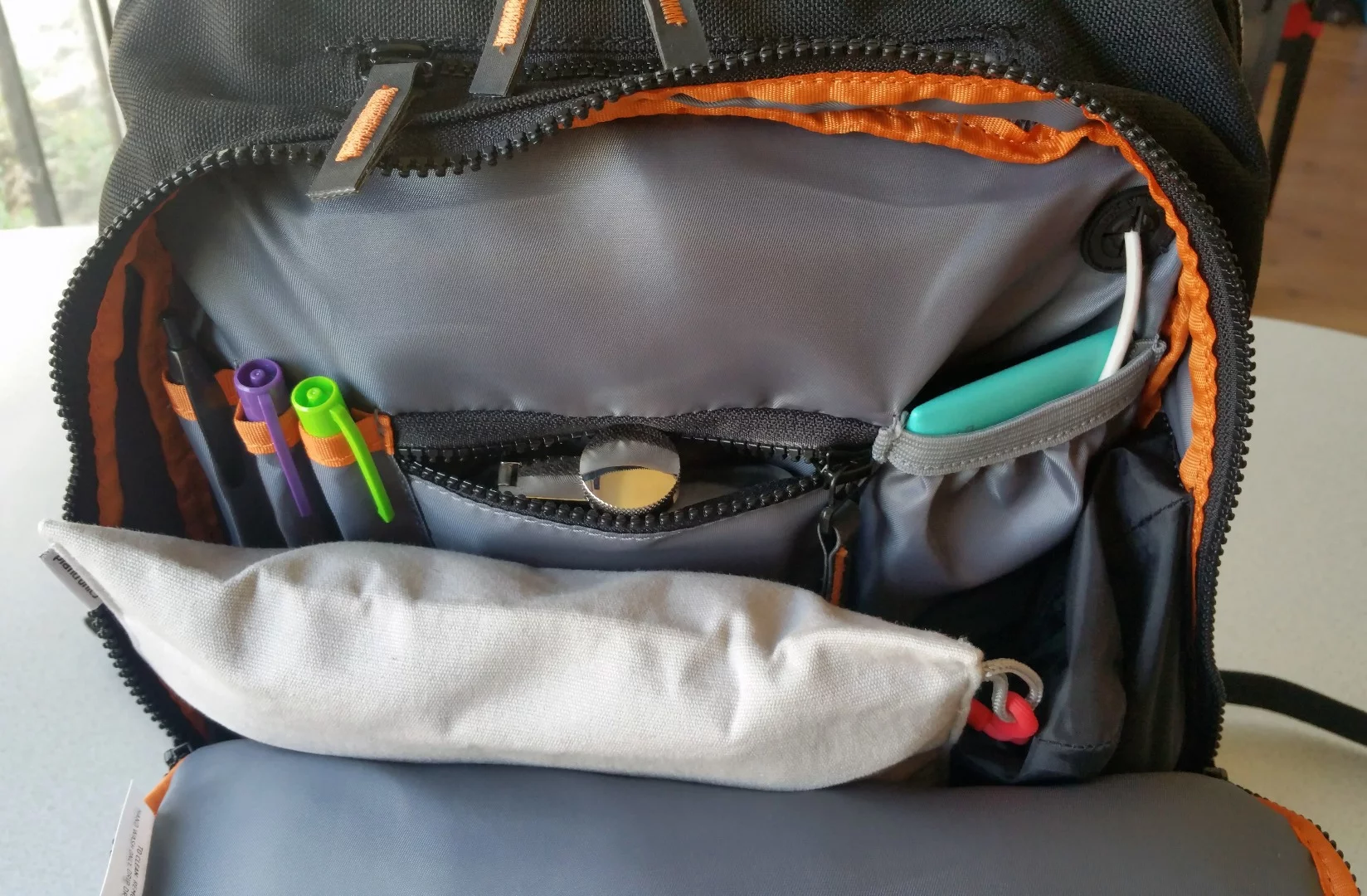 The MOS Pack's front compartment unzips half-panel, offering pockets to store pens and smaller items