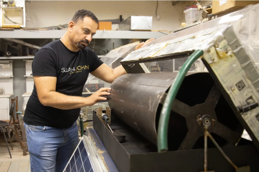 Research engineer Alharbawi Naseer Tawfiq Alwan works with the prototype solar still