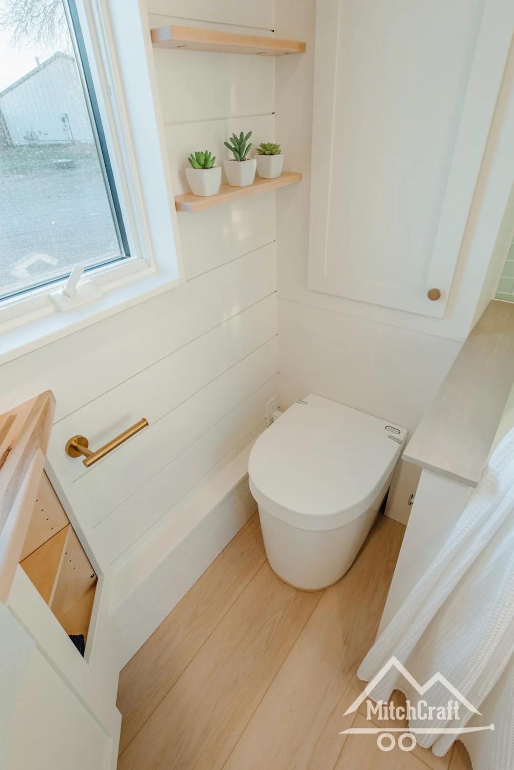 The toilet is tucked away to save space, without the need for doors
