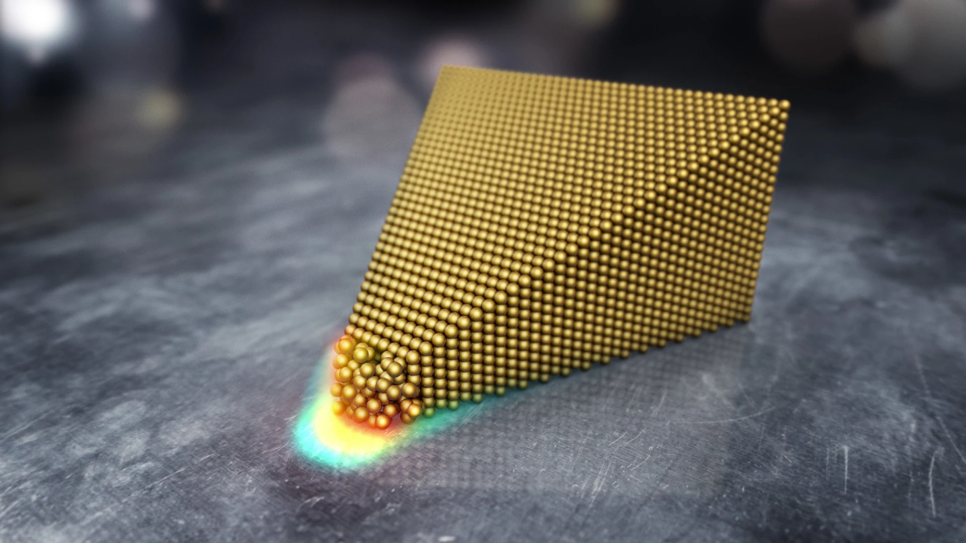 An illustration of surface atoms of a gold cone being excited by an electric field, which causes them to break their molecular bonds and effectively melt at room temperature